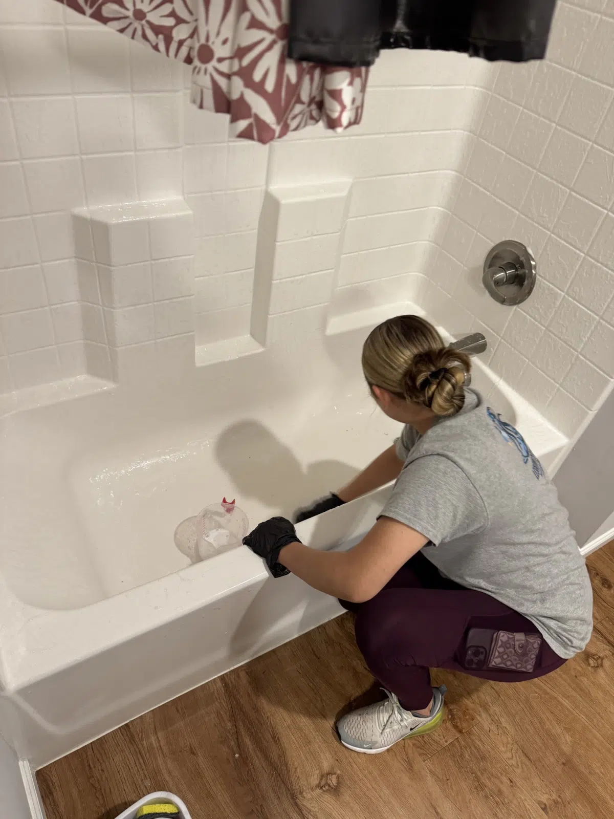 Cleaner in gloves scrubbing the edge of a white bathtub — Leskuin Cleaning LLC in Springfield